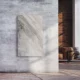 Natursteinheizung Palisandro als eleganter Wandakzent in einem Loft mit Sichtbeton und Ziegelwand – Luxuswärme