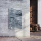 Natursteinheizung Valentina Grey als eleganter Wandakzent in einem Loft mit Sichtbeton und Ziegelwand – Luxuswärme
